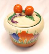 A Clarice Cliff Bizarre Lidded Preserve Pot, with fruit finials, decorated with a Crocus pattern,