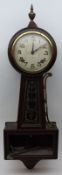 An unusual American Wall Clock, crested with a gilt metal urn finial and the circular face with
