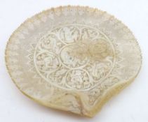 A 20th Century heavily carved mother-of-pearl Clam Shell, decorated with Eastern scenes, 7”