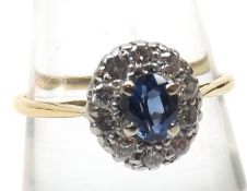 A high grade precious metal centre mid-blue Sapphire and ten small brilliant cut Diamond surround