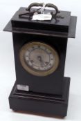 A French Ebonised Cased Mantel Clock with black cast metal carry handle, circular silvered face with