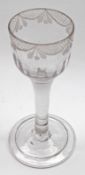 An 18th Century Wine Glass, the rim etched with garlands and lattice work over a half-fluted bowl