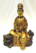 A 20th Century gilded Bronze Model of a seated Deity, seated on Bronze patinated Kaolin clutching