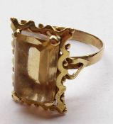 A large modern unmarked yellow metal Dress Ring, set with a single rectangular cut Citrine within