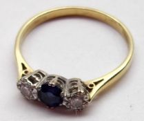 A hallmarked 18ct Gold centre mid-blue small Sapphire and two small brilliant cut Diamond Ring