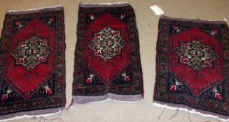 Three Turkish Mut Prayer Rugs with central lozenge designs on mainly red and black/beige field, each