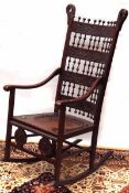 An Arts & Crafts Mahogany Rocking Armchair, the ladder back embossed in the centre with panels of
