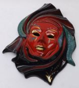 A 20th Century Wall Mask decorated with a glittered design on a red and black background, 11” long