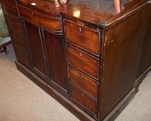 An early 19th Century Mahogany Sideboard, the top with raised edge and bowed central frieze drawer