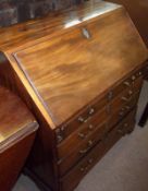 An early 19th Century Mahogany Bureau of typical form, the sloped front opening to reveal an