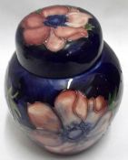 A small Moorcroft Covered Ginger Jar, decorated with Anemone pattern in reds, blues, greens etc,