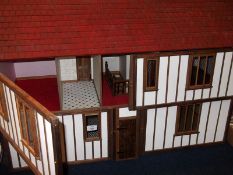 A Contemporary Tudor Style Dolls House, front opening to reveal four rooms, centrally partitioned