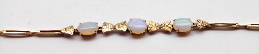 A late 19th/early 20th Century Flexible Link yellow metal Bracelet, set with three Opals (one