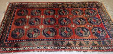A Caucasian Rug, central panel of geometric lozenges, mainly rust/orange field with green detail,