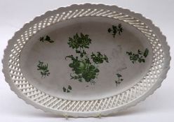 An oval Dish with pierced latticed border and the centre decorated in green with floral sprigs and