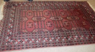 A Caucasian Carpet with multi gull border, central panel of geometric designs, mainly puce field,