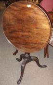 An early 19th Century Mahogany Snap Top Table, the round top to a fluted column and tripod legs with