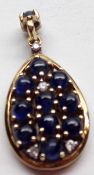 A hallmarked 9ct Gold Teardrop Design Pendant, set with Cabochon Sapphires and small brilliant cut