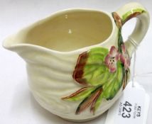 A Clarice Cliff Newport Pottery Co small Cream Jug, embossed with a floral design in pink, green and