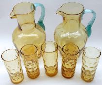 A pair of Amber Glass Lemonade Jugs with blue glass handles (one A/F) and five matching Glasses, the