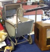 An early 20th Century Painted Wooden-bodied Dolls Pram, raised on metal wheels with rubber tyres;