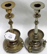 A pair of formerly Silver Plated on Brass Pedestal Candlesticks, raised on three footed bases,