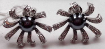 A pair of 18ct White Gold flower head design Earrings, set with a central half Black Pearl, the
