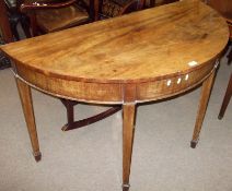 A Mahogany demi-lune shaped Side Table with moulded apron and raised on four tapering square