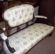 A Victorian Walnut Sofa, oval back crested with a floral moulded pediment and raised on short lyre