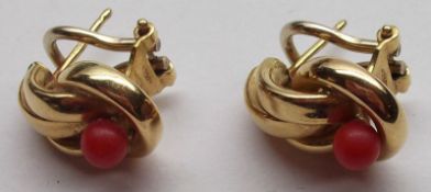 A heavy pair of high grade yellow metal curve design Earrings, each set with a small red coral
