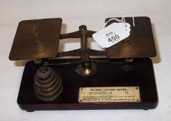 A small set of Brass Postal Scales and graduated set of six weights, fitted with small plaque marked