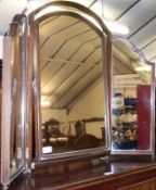 A Mahogany Triple Mirror, arched top and swivelling centre and folding sides, raised on ball feet,