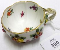 A late 19th/early 20th Century Meissen floral encrusted Novelty Cup, raised on gilt painted feet (
