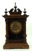 An early 20th Century Mahogany stained (probably Beech) Mantel Clock, with central urn finial over a