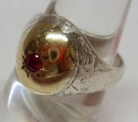 An unmarked mix metals Signet type Ring, the bulbous centre set with a small Ruby.