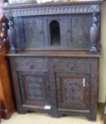 A heavily carved Oak Court Cupboard constructed from period timbers, the base with two doors and two