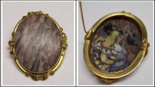 A Victorian Gold framed oval Brooch with applied wavy mounts to the edge, stone set centre, and