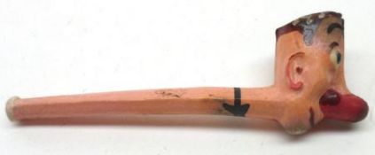 A painted Novelty Clay Pipe modelled as Pinocchio, 4 ½” long