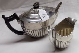 A late Victorian Tea Pot, oval shaped with half fluted decoration, Ebonised handle; together with