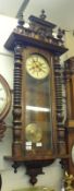 A late 19th Century Walnut Cased Vienna type Wall Clock, the overhanging cornice surmounted by a