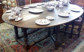 A 20th Century oval Oak gate leg Table, raised on four large turned legs, to a stretcher base, to
