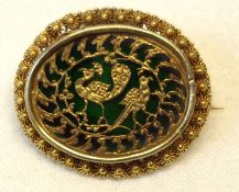 An unmarked yellow metal oval Brooch (possibly Indian) with filigree work centre featuring two