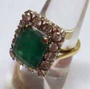 A hallmarked 18ct Gold centre emerald cut Emerald and fourteen brilliant cut Diamond rectangular