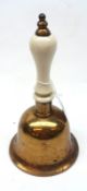 A Vintage Brass Table Bell with china handle, 8 ½” high
