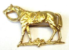 A handmade unmarked yellow metal Brooch of a saddled racehorse, measuring 36mm x 29mm maximum and