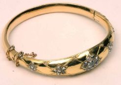 A Victorian Gold Bangle of hollow oval section, the tapering front panel featuring five panels of