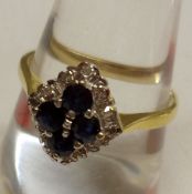 A hallmarked 18ct Gold marquise shaped Ring featuring a central raised panel of four dark blue small