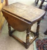 A small Oak drop leaf Table, raised on four turned legs and stretchers, 19” high