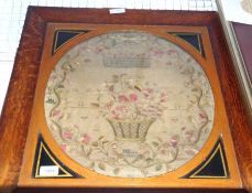 A framed early 19th Century Needlework Sampler of oval form, decorated with a border of floral vines