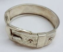 A George VI period hallmarked Silver bangle with engraved buckle front, minor defects throughout,
